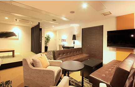 円形テーブルとベージュのソファが配された、リラックス感のあるホテルのリビング空間