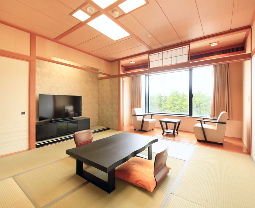 畳敷きの和室にローテーブルと座椅子が配置された、落ち着きある日本旅館の一室